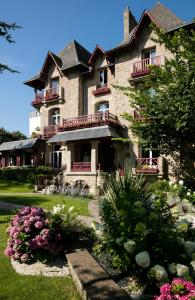 a large house with flowers in front of it at Le Castel Marie Louise in La Baule