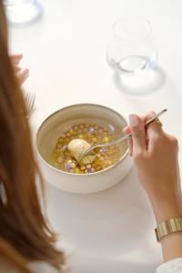 a woman is eating food from a bowl of food at Le Castel Marie Louise in La Baule