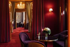 a room with chairs and a table with a vase of flowers at Le Castel Marie Louise in La Baule
