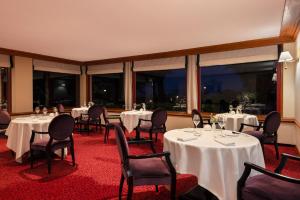 a dining room with tables and chairs and large windows at Le Castel Marie Louise in La Baule