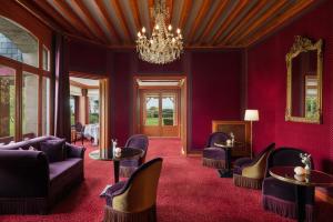 a living room with purple furniture and a chandelier at Le Castel Marie Louise in La Baule