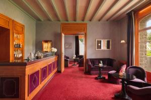 a living room with a red carpet and a bar at Le Castel Marie Louise in La Baule