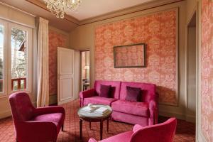 a living room with a pink couch and two chairs at Le Castel Marie Louise in La Baule