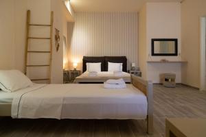 a hotel room with two beds and a mirror at Poseidon Apartments and Villas by the Sea in Sounio