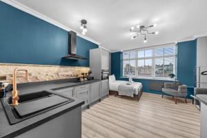 a kitchen with blue walls and a sink at Downtown Studio 1 - Harrogate Town Centre in Harrogate