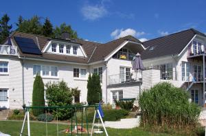 a house with a playground in front of it at Villa Vogelsang VO, Schwimmbad, Sauna in Sierksdorf