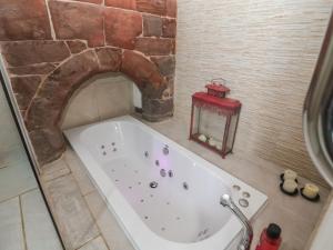 a bath tub in a bathroom with a stone wall at Monastery Hall in Chester +26 photos