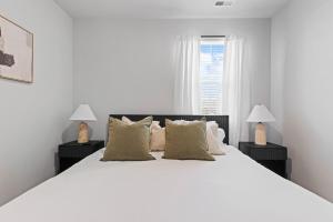 Scotts HillにあるLuxury 5BR Home Near Beaches & Downtown Wilmingtonの白いベッドルーム(大きな白いベッド、ランプ2つ付)