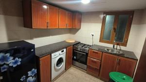 a small kitchen with wooden cabinets and a sink at STAR AL SALAM St in Salalah +23 photos