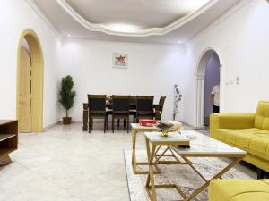 a living room with a yellow couch and a table at Hasy' House-You Jia in Jeddah