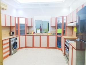 a kitchen with red and white cabinets and a washing machine at Hasy' House-You Jia in Jeddah +8 photos