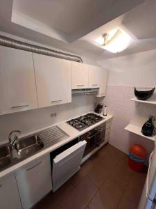 a kitchen with white cabinets and a stove top oven at Casa di fronte alle piste da sci campo da golf in Sestriere +27 photos