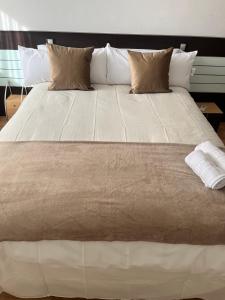a large white bed with pillows on top of it at Apartamento en Zaragoza-3 in Zaragoza