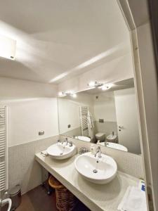a bathroom with two sinks and a large mirror at Casa di fronte alle piste da sci campo da golf in Sestriere