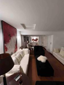 a living room with a white couch and a table at Casa di fronte alle piste da sci campo da golf in Sestriere