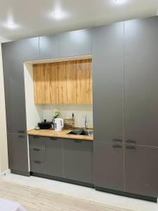 a kitchen with gray cabinets and a counter top at Apartments comfort new, Aktau 16 77 in Aktau +2 photos
