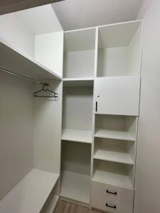 a white walk in closet with white shelves at Apartments comfort new, Aktau 16 77 in Aktau