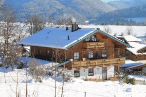 una gran casa de madera con nieve en el techo en Schmuckhäusl, en Reit im Winkl