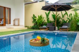 a swimming pool with a wicker basket and an umbrella at Lasterra - New Stylish Villa with Huge Pool - Steps from the Beach & Ultimate Luxury in Uluwatu +2 photos