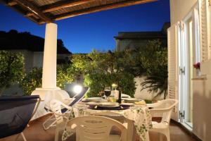 una mesa y sillas en un patio por la noche en Fiori di Arancio, en Lipari