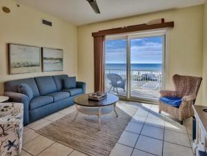 a living room with a blue couch and a view of the ocean at Bodacious Beach Retreat Condo in Destin in Destin