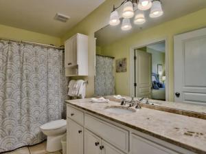 a bathroom with a sink and a toilet and a mirror at Bodacious Beach Retreat Condo in Destin in Destin +7 photos