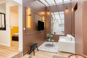 a living room with a white couch and a tv at L'escale - Proche ORLY - Paris - RER C in Villeneuve-le-Roi