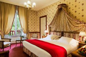 a bedroom with a large bed with a red blanket at Le Castel Marie Louise in La Baule
