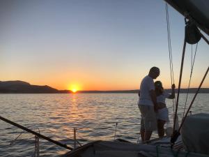 Un uomo e una donna in piedi su una barca al tramonto di Perseus Sailing Cruises a Souda (Suda)