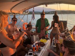 Un gruppo di persone con cappelli da festa su una barca. di Perseus Sailing Cruises a Souda (Suda)