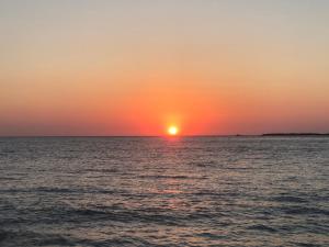 un tramonto sull'oceano con il sole all'orizzonte di Perseus Sailing Cruises a Souda (Suda)