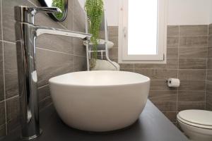 bagno con lavabo bianco e servizi igienici di arena's casa vacanze a La Caletta Altre 24 foto