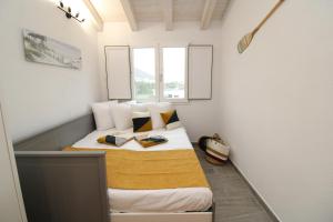 un piccolo letto in una piccola stanza con finestra di arena's casa vacanze a La Caletta