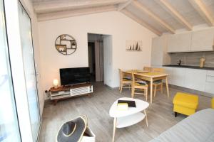 un soggiorno con un tavolo e una cucina di arena's casa vacanze a La Caletta