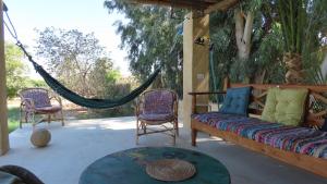 a porch with a couch and chairs and a hammock at Ohana retreat guest house in Tunis