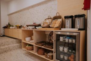 a kitchen with a shelf with dishes and baskets at CasadoRioGuestHouse in Constância