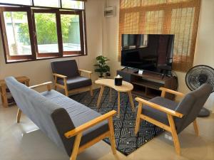 a living room with a couch and chairs and a tv at Aimei Bang Saray in Bang Sare