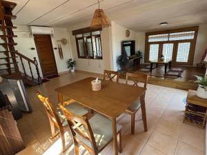 a dining room with a wooden table and chairs at Aimei Bang Saray in Bang Sare