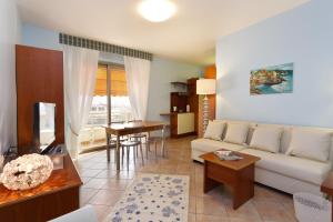 ein Wohnzimmer mit einem Sofa und einem Tisch in der Unterkunft Residence Dei Due Porti in Sanremo