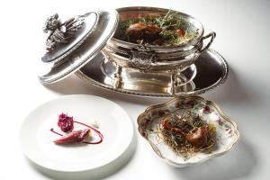 a table with two plates of food and a silver tray at The Xara Palace Relais & Chateaux in Mdina