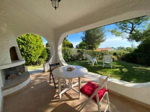 a patio with a table and chairs and a yard at Villa trilocale CON SPIAGGIA E PISCINA incluse - Taunus Vacanze Villa Primule in Numana