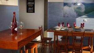 comedor con mesa y sillas con copas de vino en Prime Oceanfront Apartment, en Ericeira