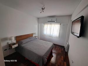 a bedroom with a bed and a flat screen tv at Departamento a estrenar con pileta in Buenos Aires +6 photos