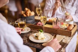 a group of people sitting at a table with food and glasses of wine at Wellnessresort & Hotel De Valkenberg in Rheden +15 photos