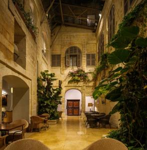 a room with tables and chairs in a building at The Xara Palace Relais & Chateaux in Mdina