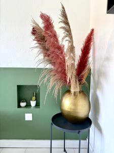 een vaas met veren op een kruk bij La Bulle de Maloma - Cocon pour Duo, Plage à 2 min in Grand-Bourg +10 foto's