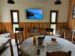 een eetkamer met een tafel met wijnflessen en glazen bij Casa nueva en recinto privado in Licán Ray