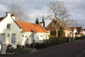 a white house with an orange roof on a street at Maison A La Mer in Retranchement