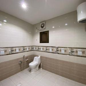 a bathroom with a toilet and a television in it at بانوراما لشقق المخدومة اقتصادية in Dammam +12 photos