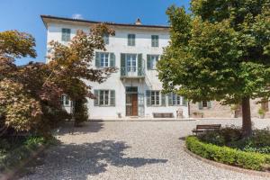 a large white house with a large driveway at Casa Rovelli in Alfiano Natta